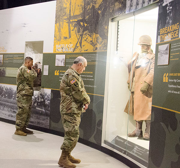 Two people in US Army uniform reading from an exhibit at the Don F. Pratt Museum.